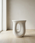 Terrazzo Garden Stool in speckled white with an oval cut-out, on pale oak flooring by a window