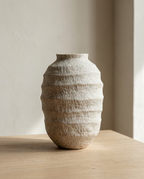Wabi-Sabi Stoneware Vase, a speckled cream and tan ribbed oval vessel on a pale oak surface
