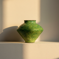 Wide-shouldered jar in bright emerald crackle glaze on a plaster ledge