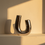 Mirror-polished silver vase bent into a continuous U