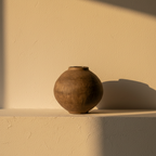 Round moon jar in unglazed brown clay with a small mouth