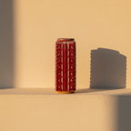 Ribbed rectangular vase in a glossy oxblood glaze on a plaster ledge