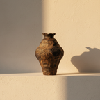 Bulbous vase in a blistered dark volcanic glaze with a ruffled rim