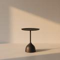 Round black side table on a flared pedestal foot