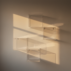 Clear acrylic floating box shelves on a plaster wall