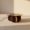 Round glass coffee table on a cluster of rounded brown columns