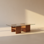 Glass-topped coffee table over an angular wooden storage base