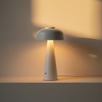 White frosted cordless desk lamp lit from beneath its shade