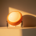 Orange glass globe lamp lit, white inner globe glowing