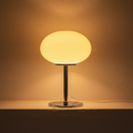 Yellow glass bedside lamp glowing on a chrome stem