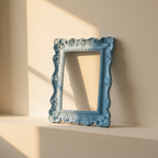 Powder blue photo frame moulded with lace-like scrollwork