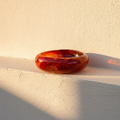 Swirled red and amber glass dish banded like a cut agate