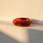 Swirled red and amber glass dish banded like a cut agate