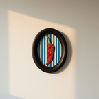 Red chilli on blue and white stripes in a black oval frame