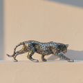 Silver leopard figure mid-stride on a limewash plaster ledge