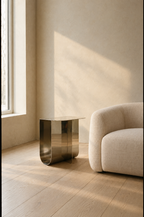 Mirror polished folded steel side table reflecting a plaster wall