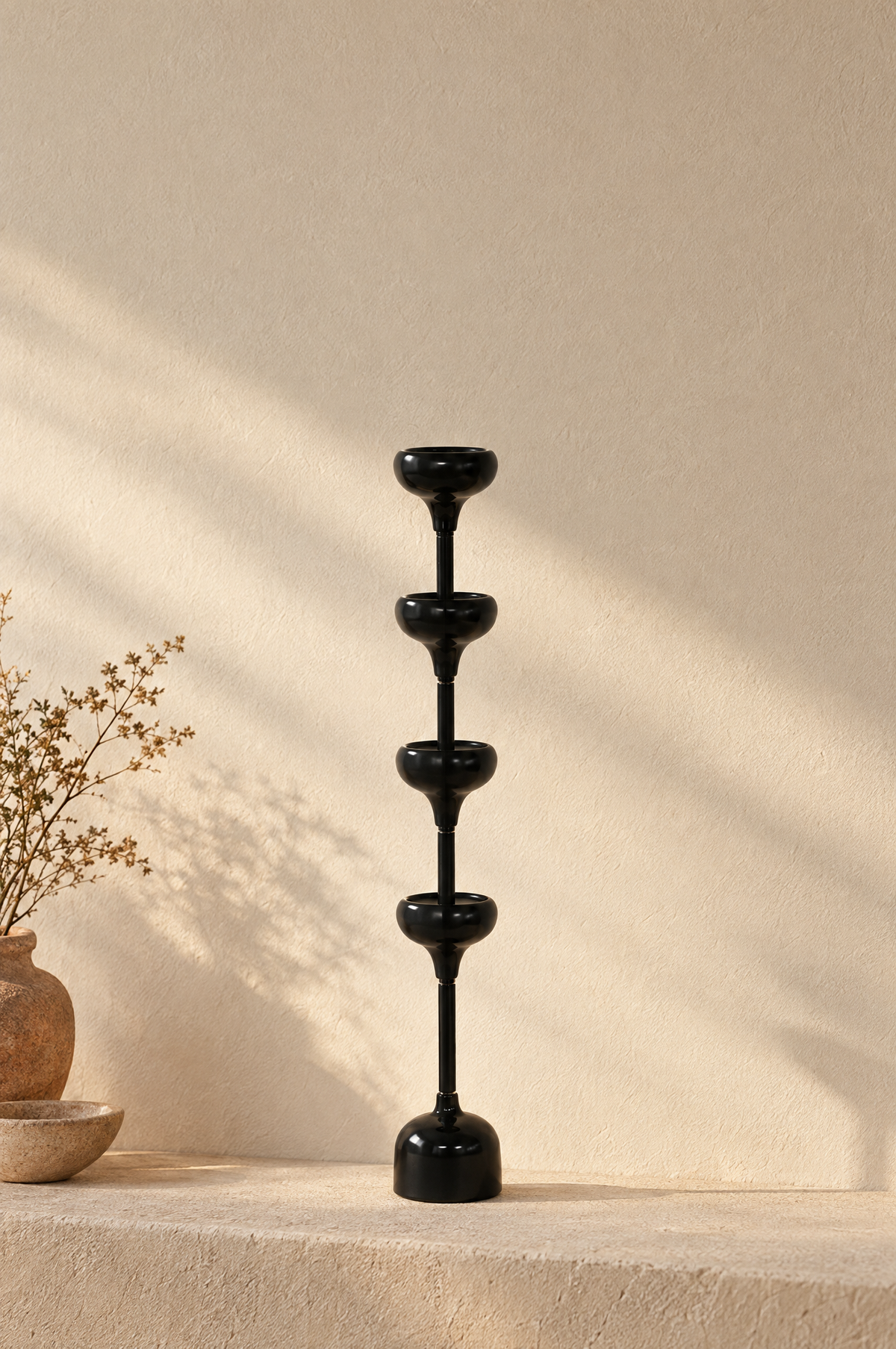 Tall black candlestick with four stacked candle cups