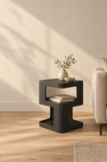 Matte black side table with two opposed rectangular cut-outs