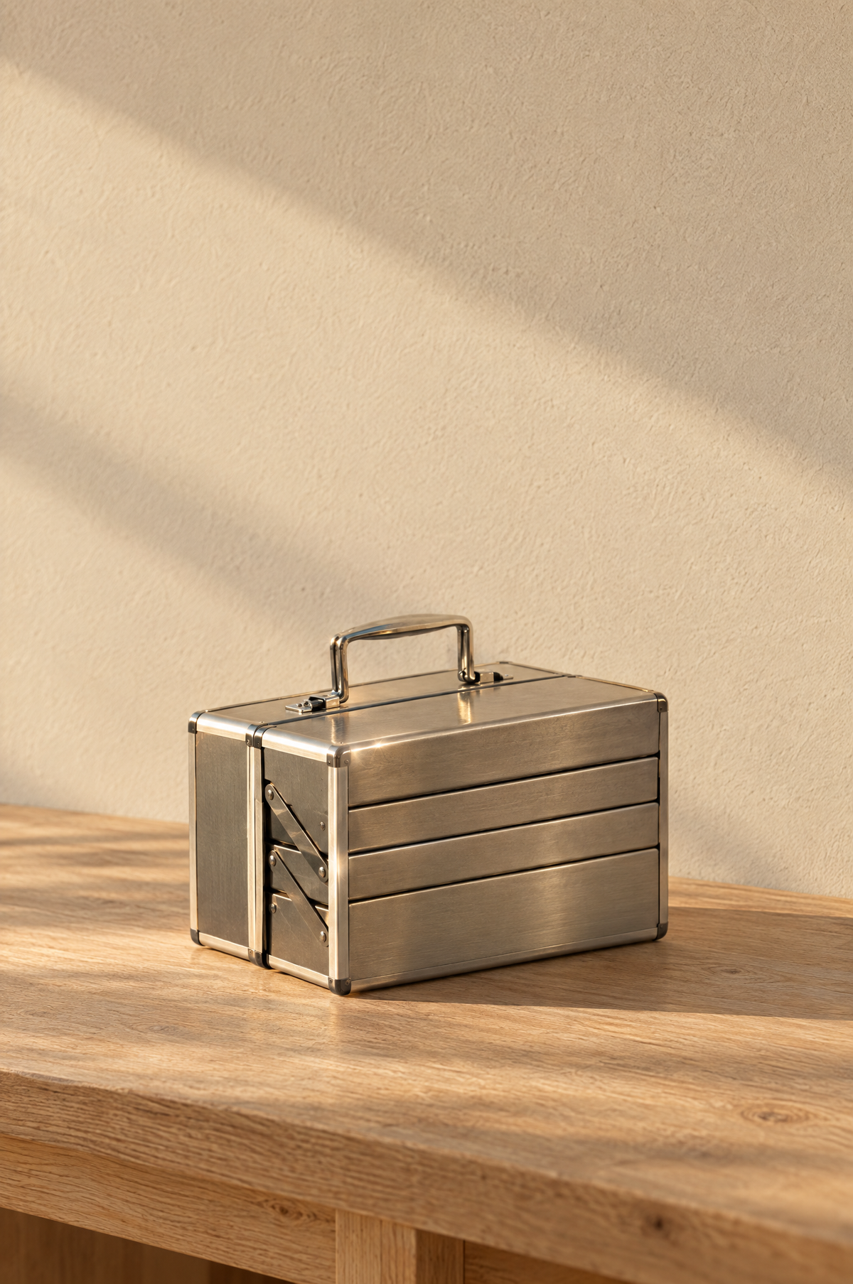 Brushed steel cantilever toolbox closed on a workbench