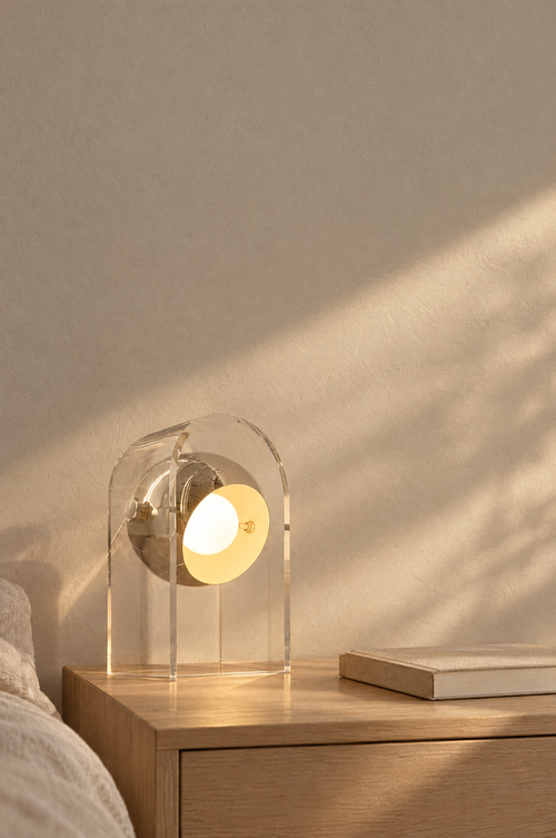 Clear acrylic bedside lamp with a warm glowing disc