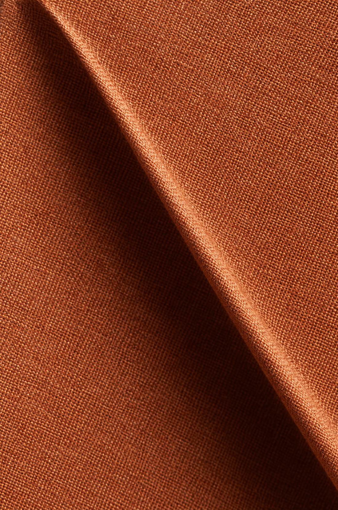 Close-up of a sculptural crease in the terracotta fabric