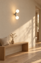 Two-arm chrome wall light glowing in a quiet hallway